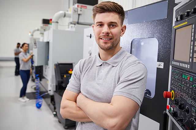 Employee standing near CNC machinery
